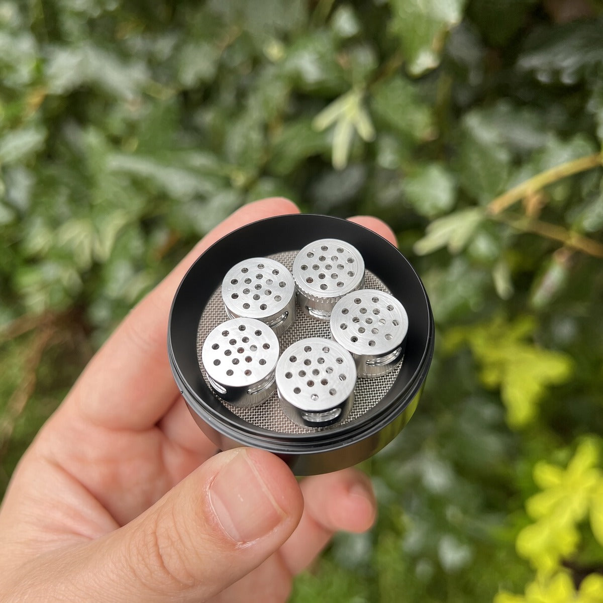 5 Armour dosing capsules sitting inside the grinder's mesh screen chamber (capsules shown sold separately)